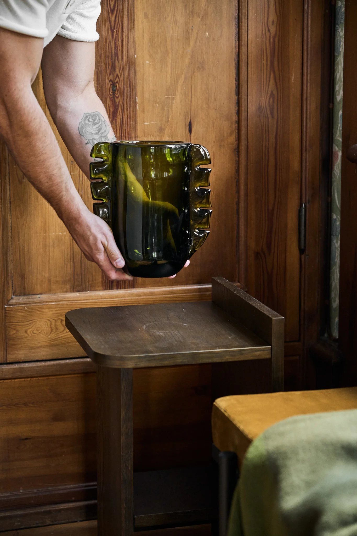 Olivgrün ist einer der Farbtrends für unsere Innenräume im Jahr 2026, hier sehen Sie eine Vase, die auf einen Beistelltisch gestellt wird.