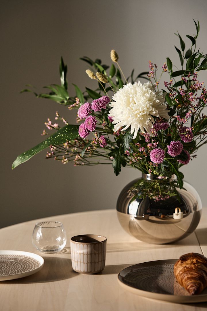 Muttertagsgeschenke sollten im besten Fall ausdrücken, was Ihnen Ihre Mutter bedeutet. Schenken Sie Ihr zu einem weiß-pinkfarbenen Blumenstrauß noch die passende Vase dazu, hier die silberne Amico Vase von Hilke.