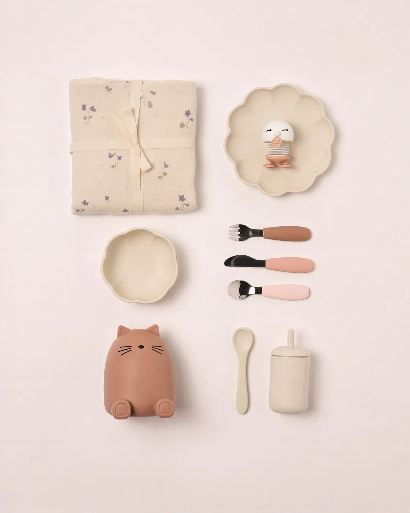 Babyset: geblümte Decke, Muschelplatte mit Vogelspielzeug, Schale, Katzenbehälter, Besteck, Löffel und Becher mit Deckel.