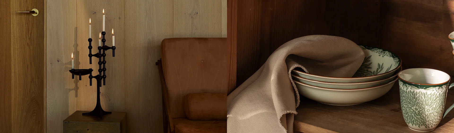 Elegantes Esszimmer mit langem Steintisch, dunklen Holzstühlen, einem Messingkerzenständer, einer einzigartigen Messing-Wandleuchte und einem großen goldgerahmten Spiegel.