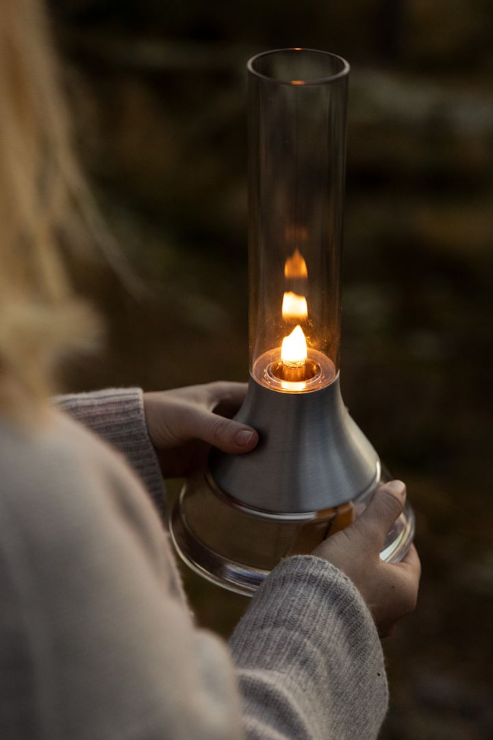 Lagom im Jahreslauf: Eine Frau hält die Fyr Petroleumlampe von Design House Stockholm in der Hand.