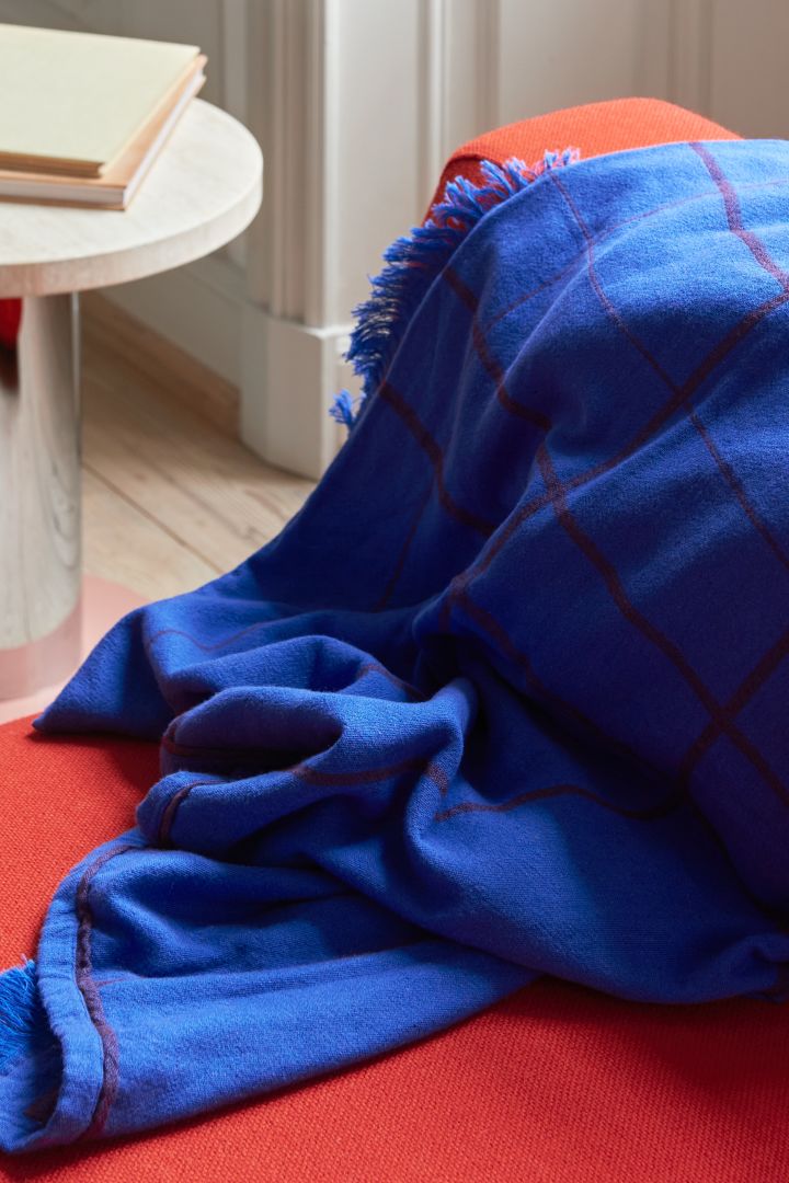 Starke Akzentfarben wie Rot und Blau zeigen sich hier bei &tradition in Form eines roten Sofas und eines blauen Plaids – ein perfektes Beispiel dafür, wie die Wohntrends für 2023 ausschauen.