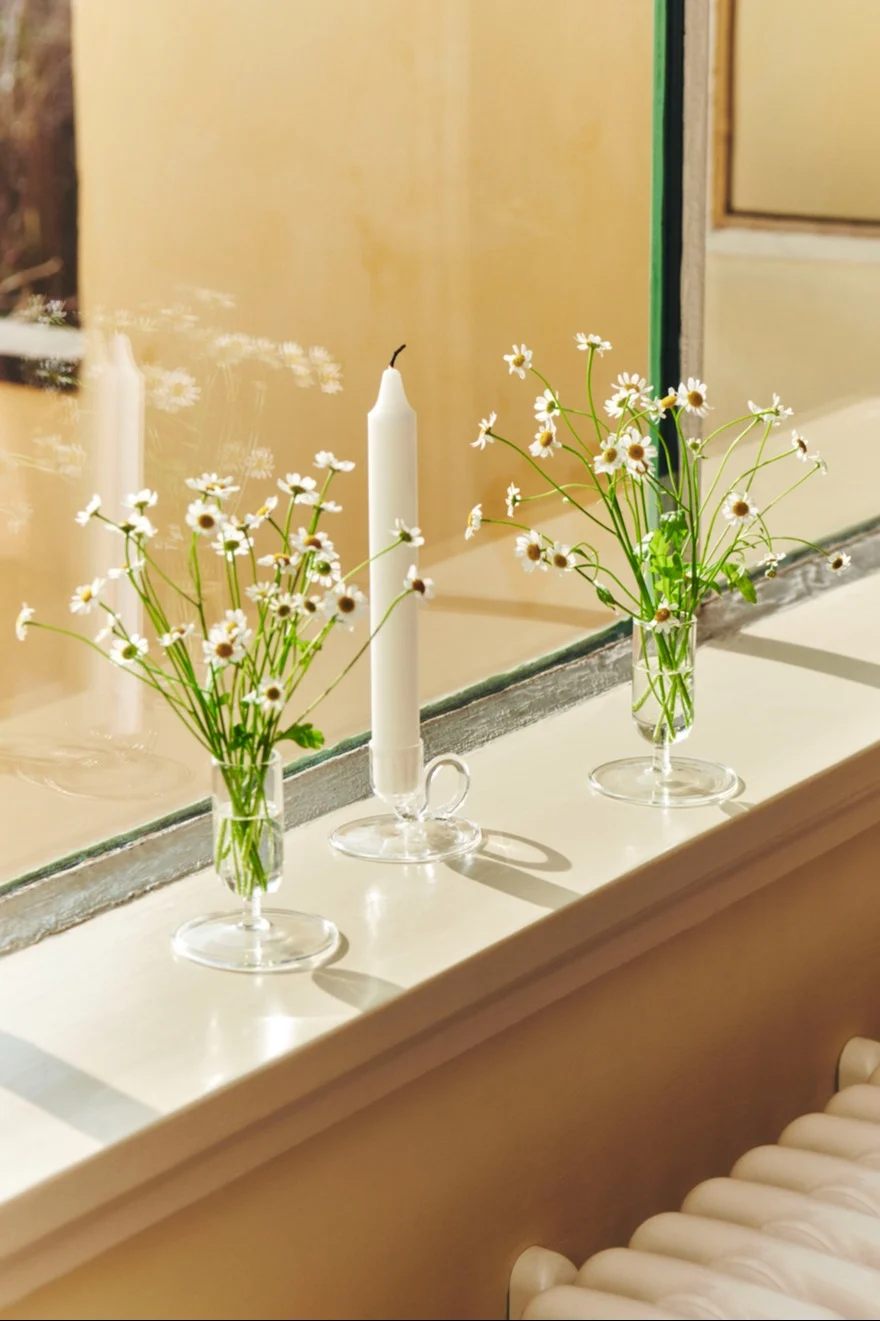 Dekorieren Sie die Fensterbank mit frühlingshaften Blumen wie Gänseblümchen und präsentieren Sie sie in den Tiny Vasen von HAY.
