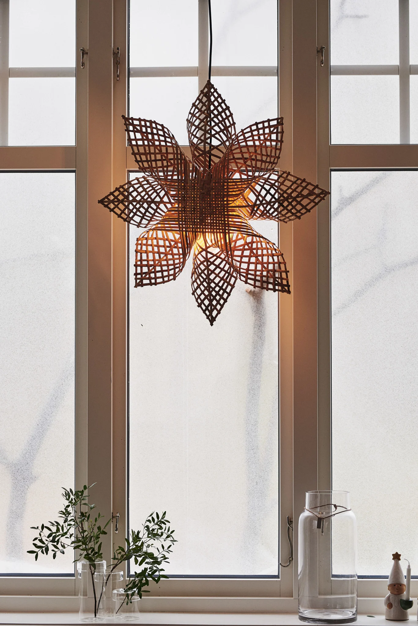 Der skandinavische Weihnachtsstern Carol von PR Home hängt in einem Fenster.