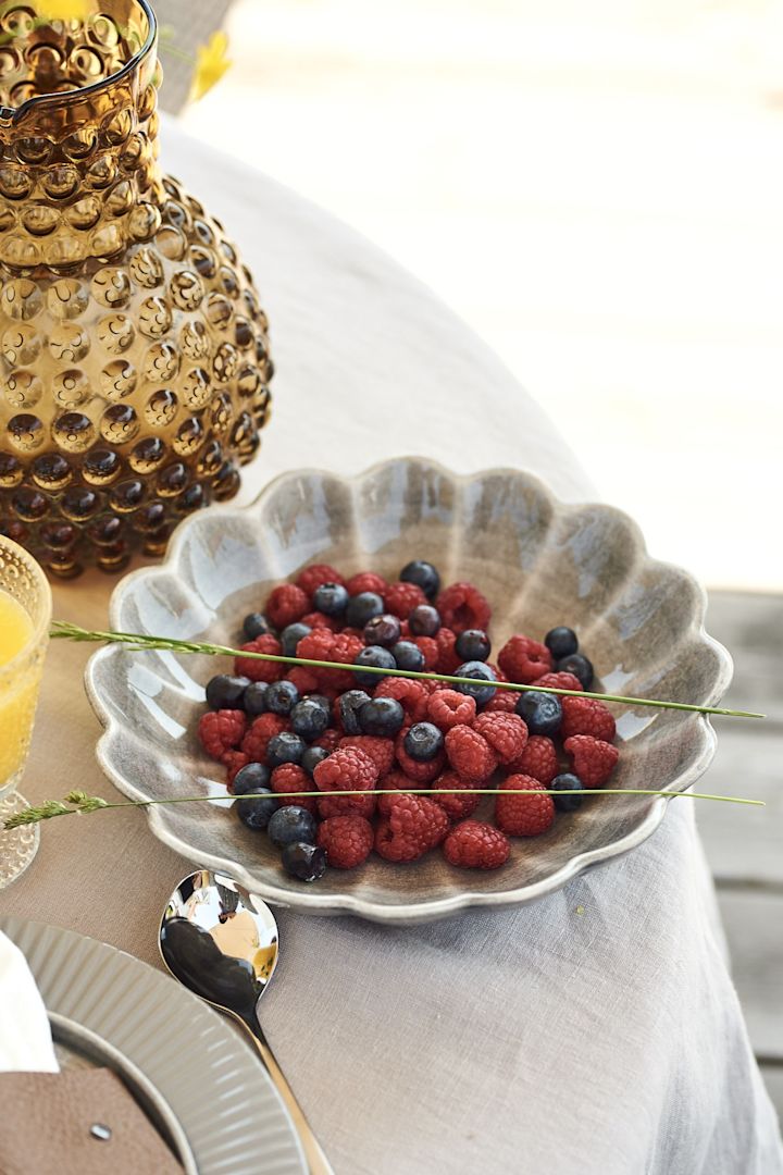 Himbeeren und Blaubeeren, serviert aus einer großen grauen Schale von Mateus beim Sommerfrühstück. 