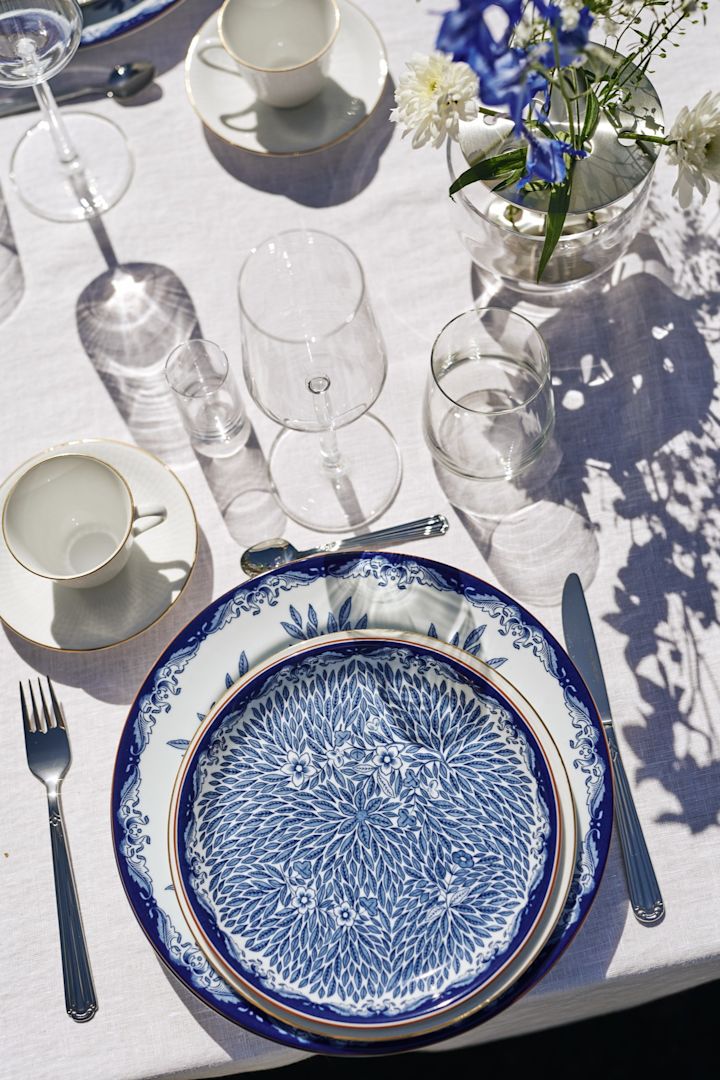 Die blau-weiße Tischdeko ist ein Klassiker in Schweden zu Mittsommer. Hier sehen Sie ein Tischgedeck bestehend aus dem blauen-weißen Ostindia-Geschirr von Rörstrand.