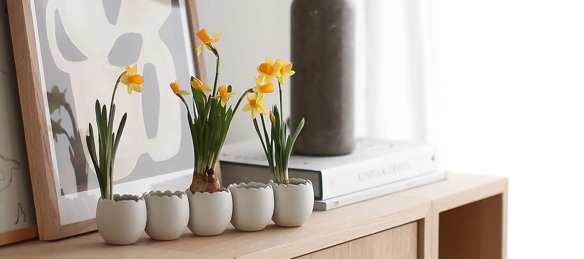 Auf einem Tablett stehen zwei Ball Vasen in verschiedenen Formen und Größen von Cooee Design mit Frühlingsblumen, daneben mehrere Triplets Osterhasen von DBKD im Zuhause von @sachi_roooom.
