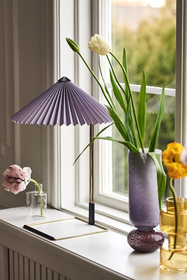 Im Frühling 2023 kehrt der Retrolook zurück. Holen Sie sich diesen Trend mit der Matin Tischleuchte mit ihrem lilafarbenen Lampenschirm nach Hause!