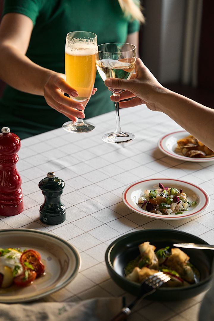 Chateau-Bier- und Weingläser von Kosta Boda bei einer Dinnerparty mit HAY-Tellern. 