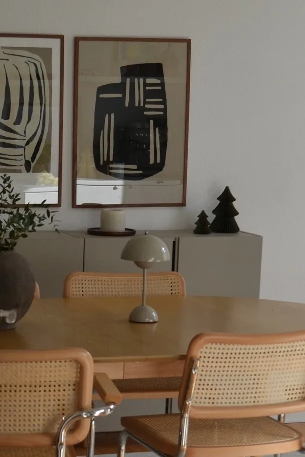 Greige ist bei den Farbtrends für 2025 wieder im Kommen. Hier sehen Sie die Flowerpot VP9 Tischleuchte von &Tradition auf einem Esstisch aus Holz.