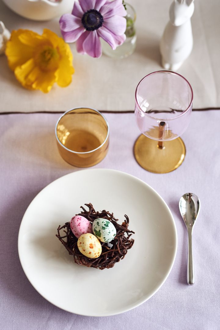 Kreieren Sie einen festlich gedeckten Ostertisch in frühlingshaften Pastellfarben mit leckeren Schoko-Vogelnestern auf dem Arabia-Teller zusammen mit Tint-Gläsern und Weingläsern von HAY.