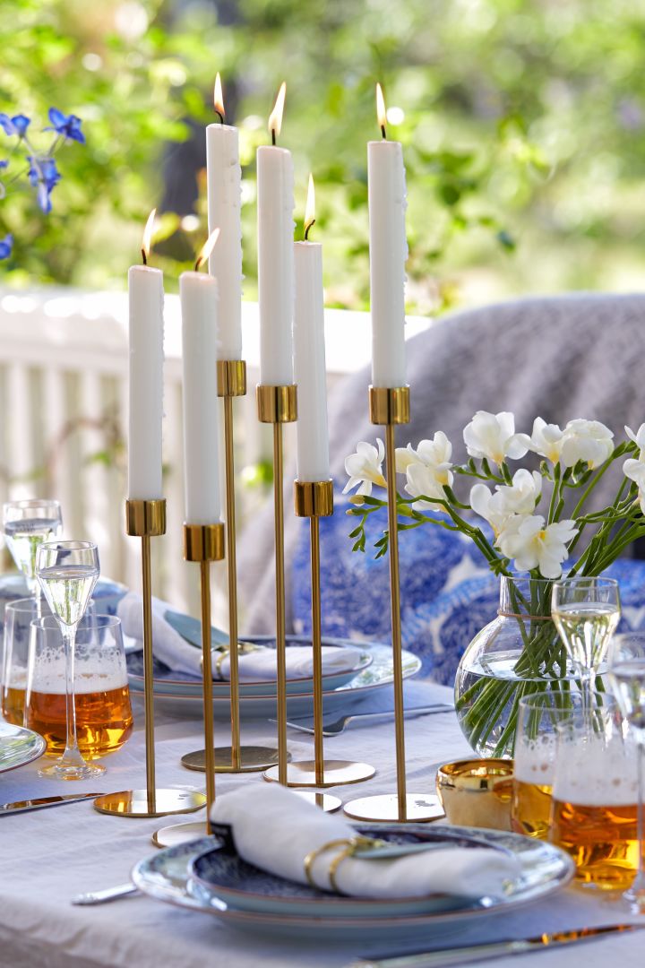 Decken Sie den Tisch für Mittsommer mit Kerzenhaltern aus Messing, um Ihrem Mittsommertisch einen klassischen Stil zu verleihen. 
