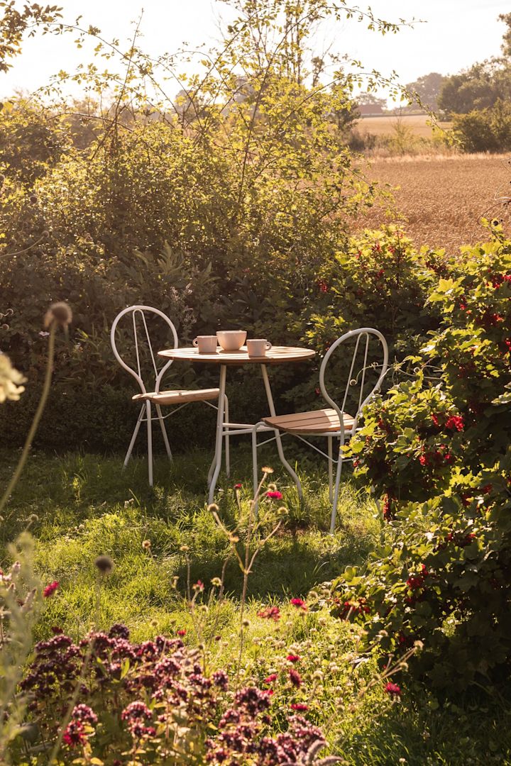 Gartenmöbel-Trends 2025: Ein wunderschöner grüner Garten, mittendrin stehen der Tisch und zwei Stühle aus der Pia-Kollektion von Gärsnäs.