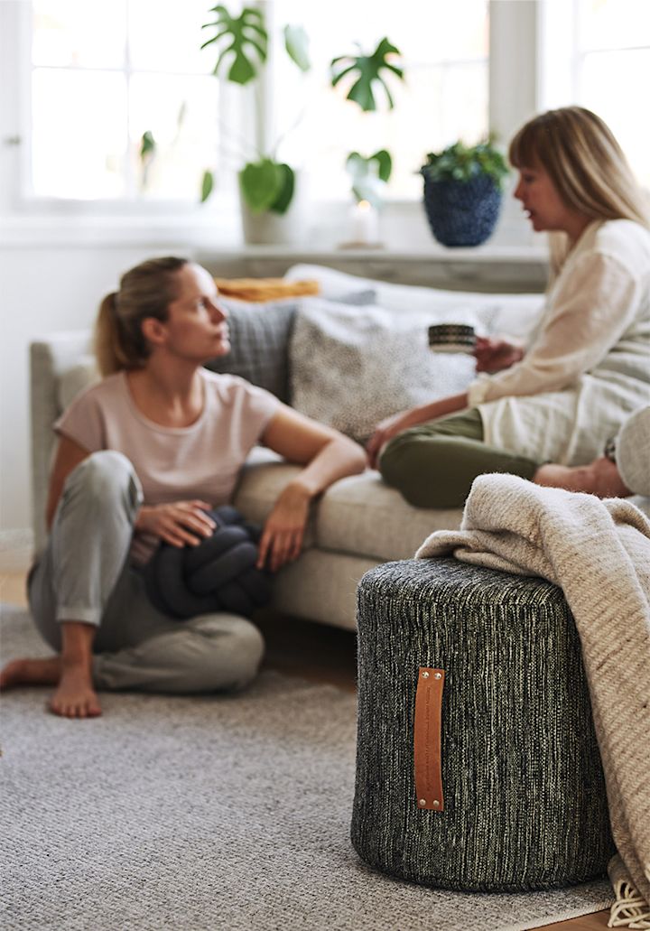 Ein hyggeliges dekoriertes Wohnzimmer, in dem weiche Textilien und bequeme Möbel wie ein Sitzkissen von Design House Stockholm zu gemütlichen Momenten einladen.