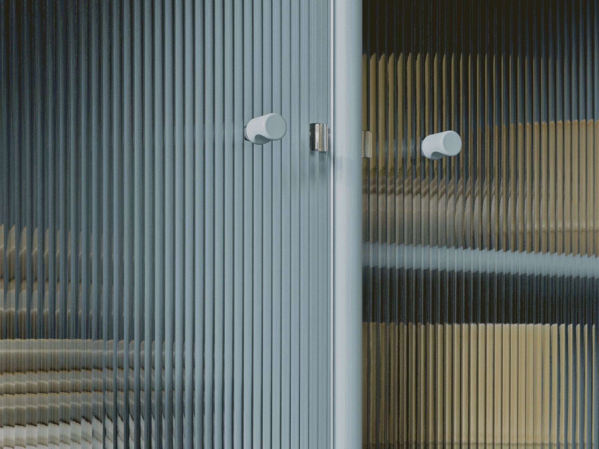 Nahaufnahme einer geriffelten Glastür mit zwei hellen runden Griffen, zeigt verzerrte Farben durch die durchscheinende Textur.