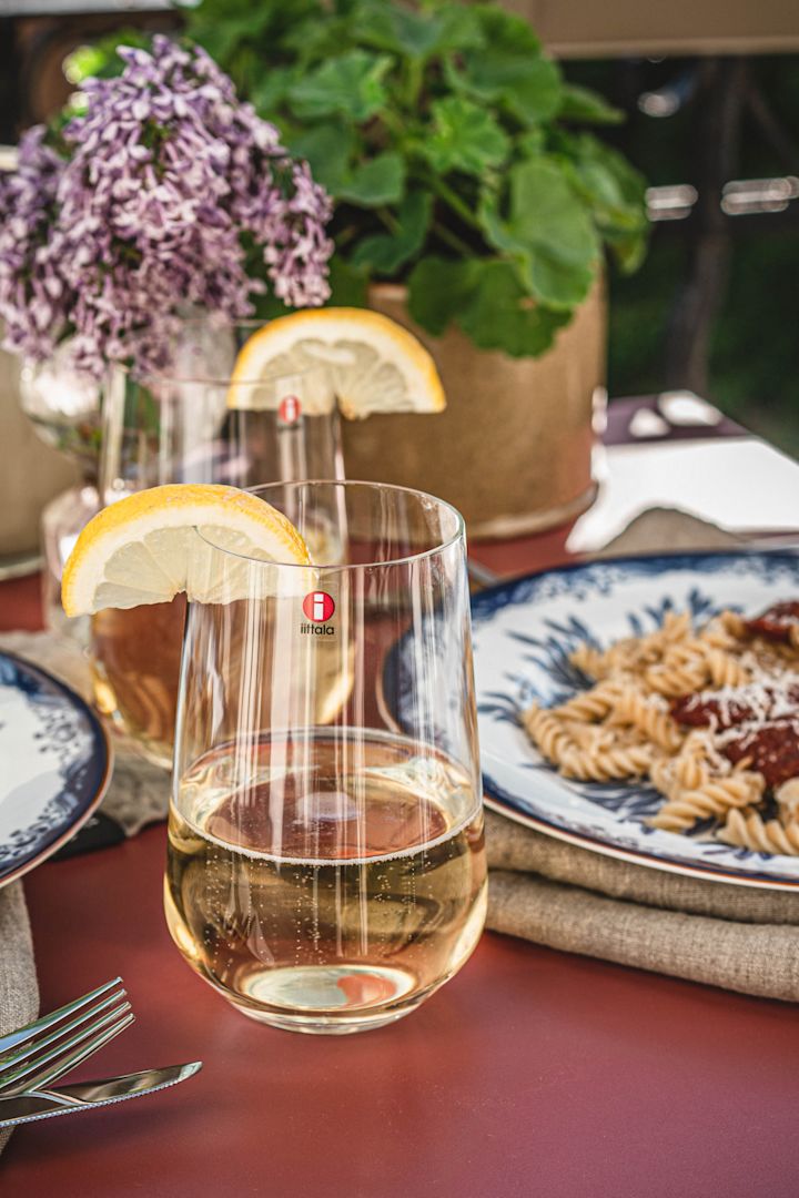 Essence Trinkglas mit einem erfrischenden Sommergetränk, das zum Abendessen serviert wird. 