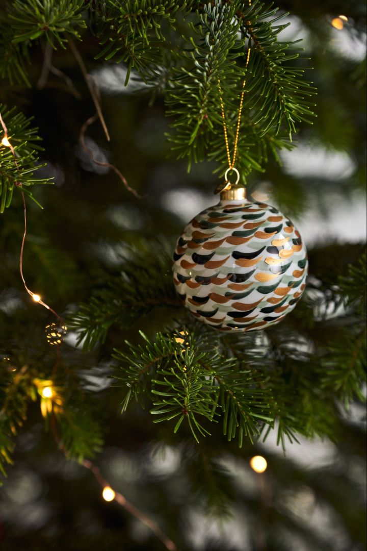 Skandinavische Weihnachtsdekorationen 2023: Hier sehen Sie eine Souvenir Weihnachtskugel Pinselstrich von Holmegaard an einem Tannenbaum hängen.