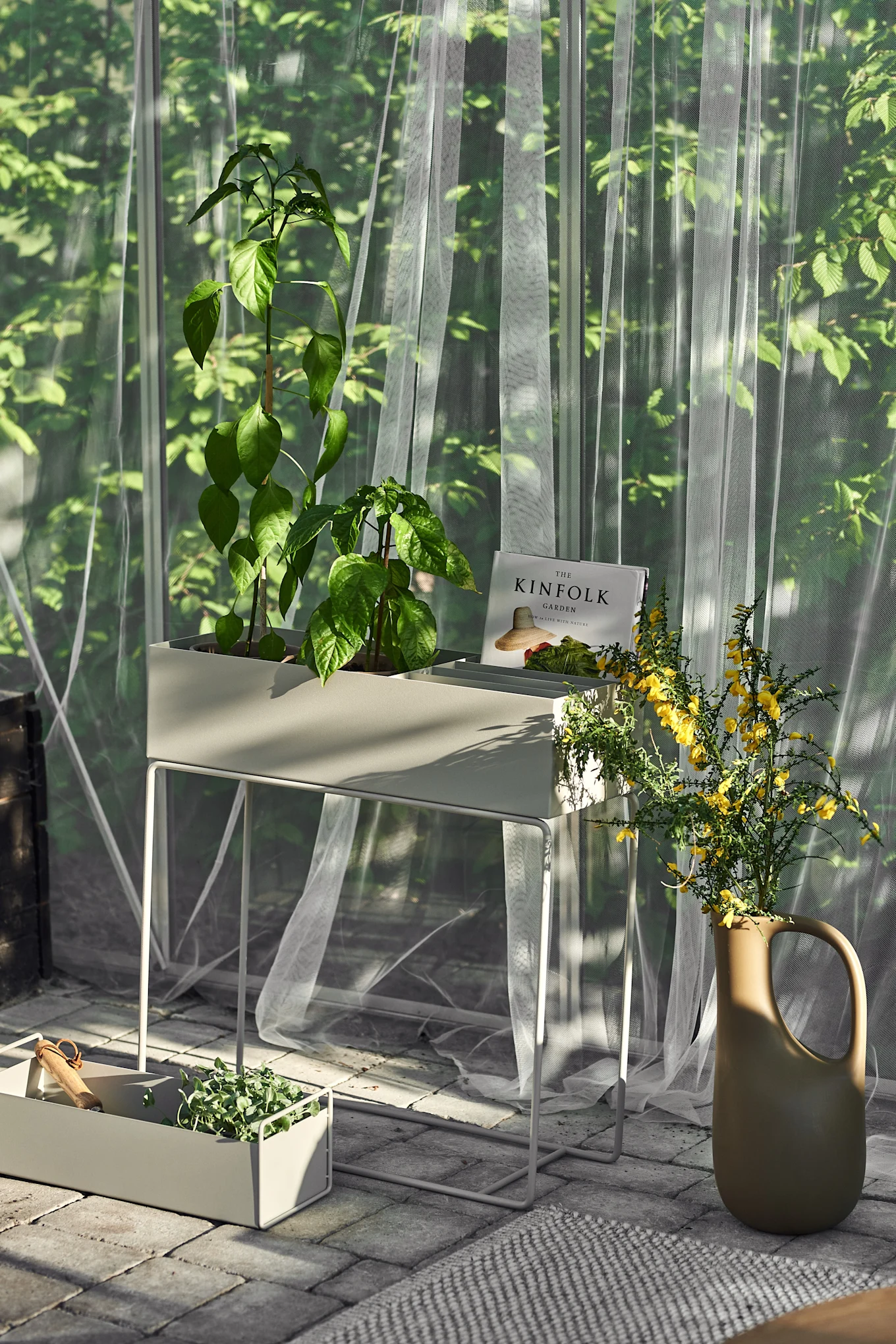 Eine gemütliche Terrasse, mit Stoff behangen und mehreren Plantboxen von Ferm Living.