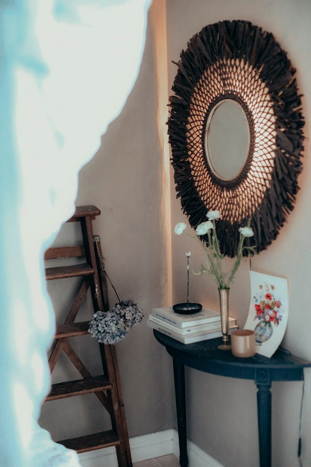 Die perfekte Boho Deko: Die Boho Wandleuchte mit Spiegel von Globen Lighting hängt in einem im Boho-Stil dekorierter Zimmer.