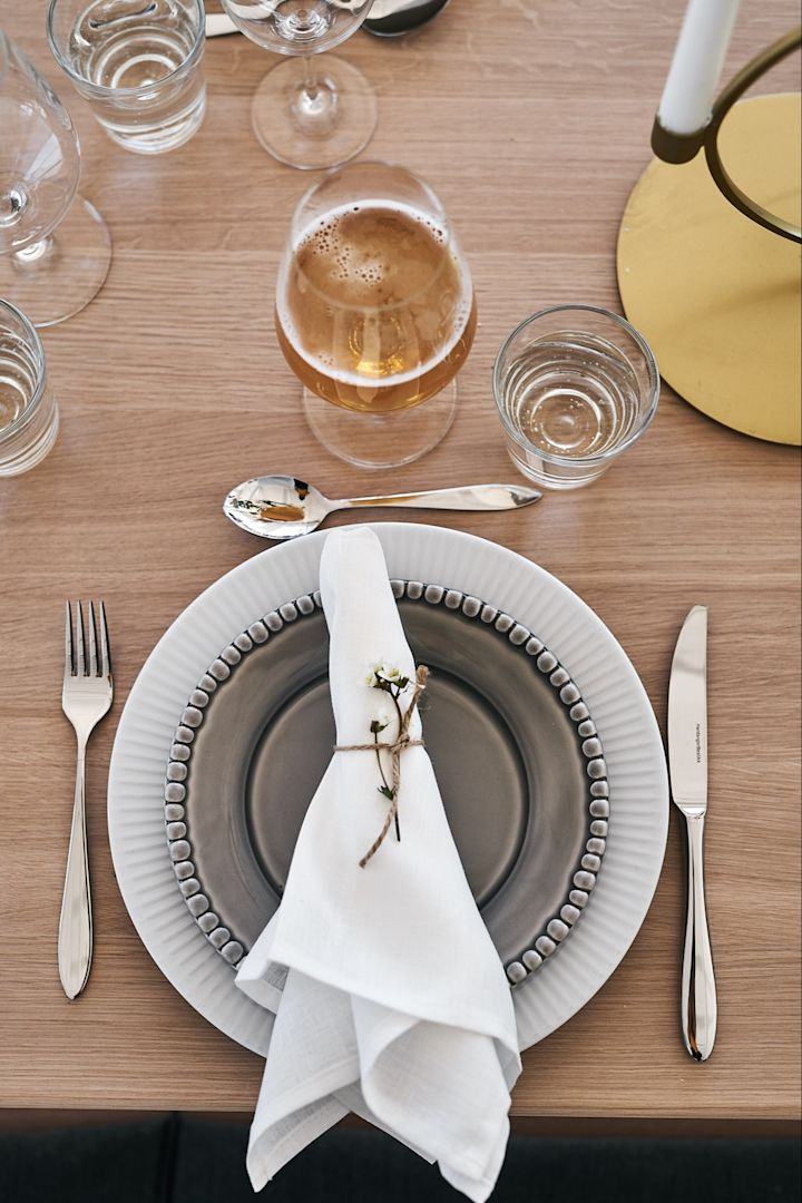 Mittsommer mit gemischtem Geschirr, weißen Leinenservietten und eleganten Gläsern von Holmegaard - alles in erdigen Farben.