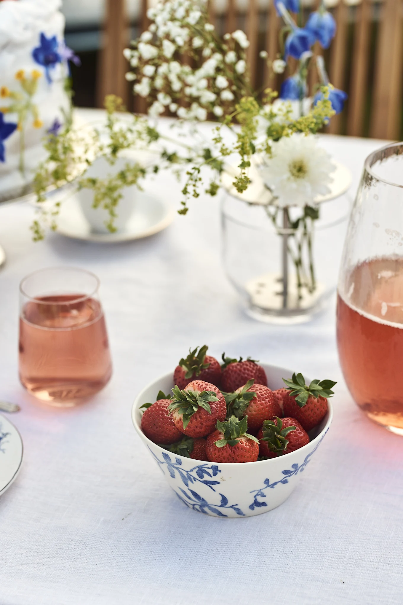 Erdbeeren in jeder Form sind ein Muss zu Midsommar in Schweden, hier in der Havspil Schale von Scandi Living auf einem gedeckten Tisch draußen.
