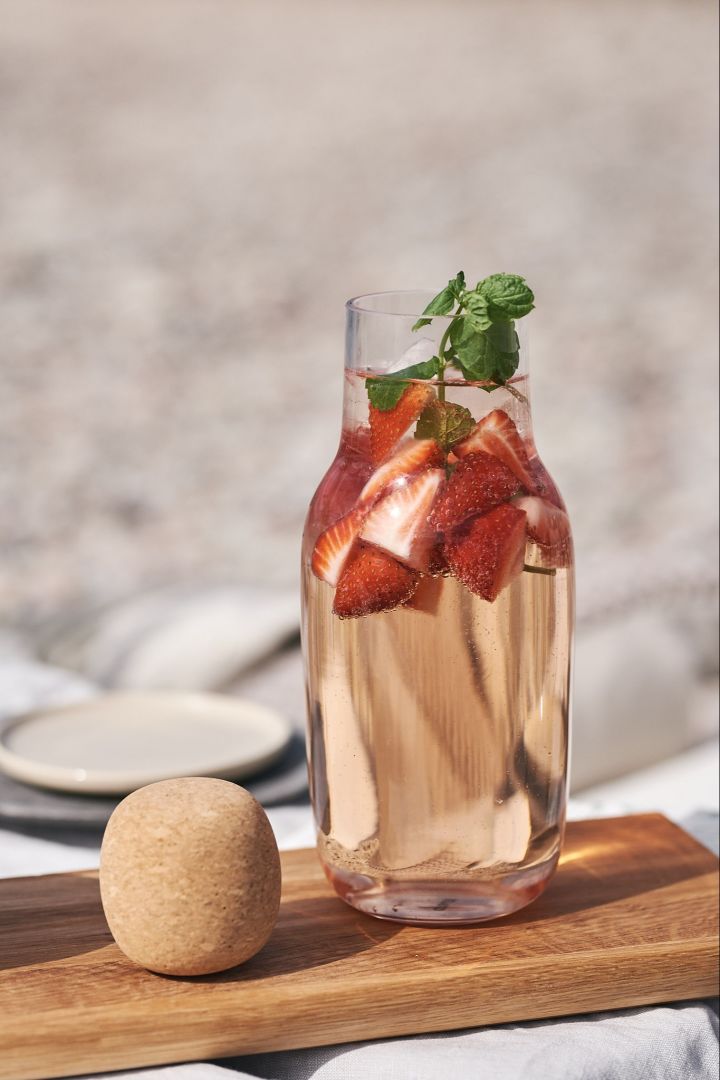 Einfache Sommergetränke -  eine erfrischende Variante von Sangria - Erdbeeren mit Minze, serviert in einer Karaffe. 