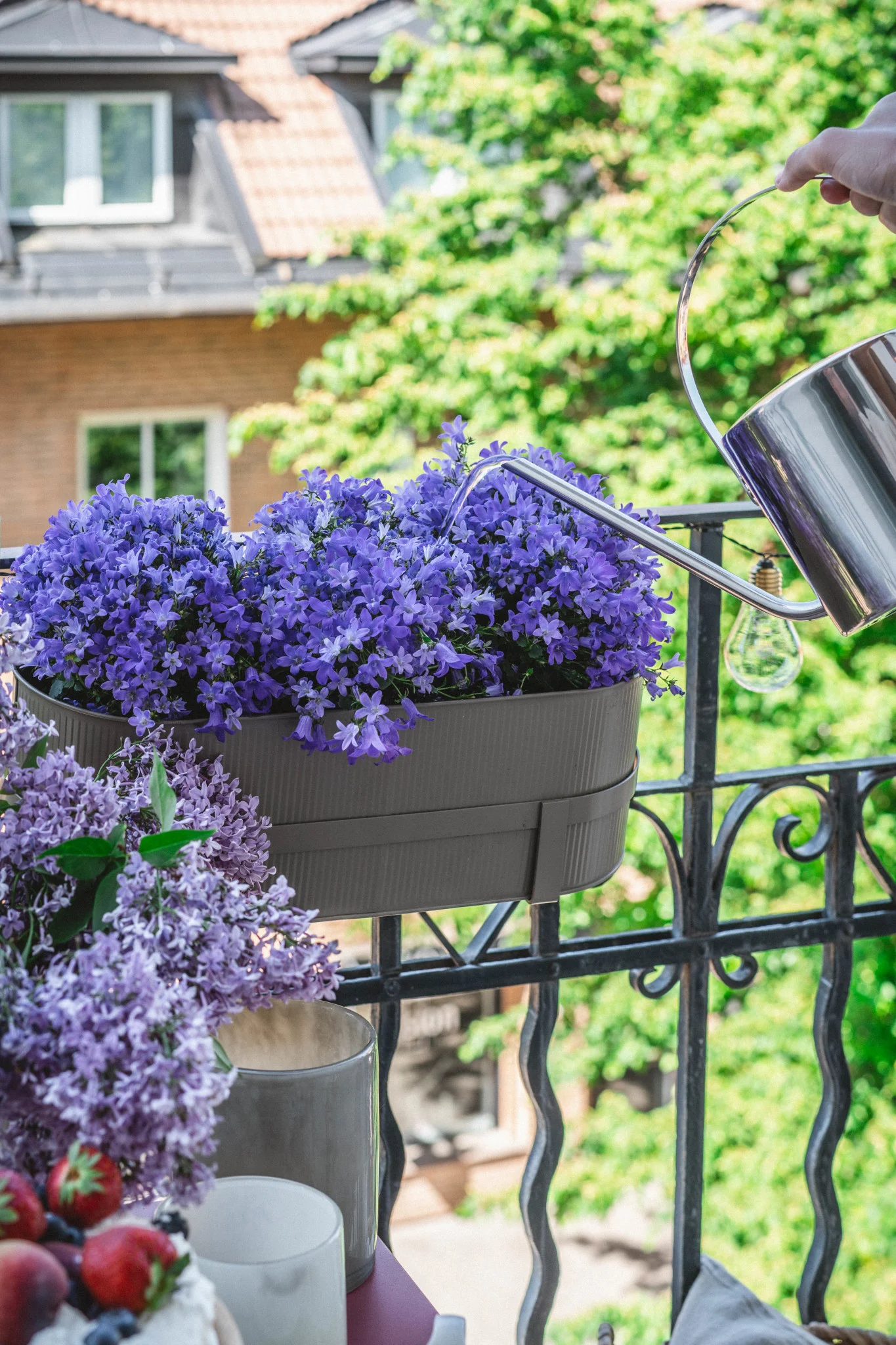 Hier sehen Sie den Bau Blumentopf in Beige von Ferm Living an einem Balkongeländer.