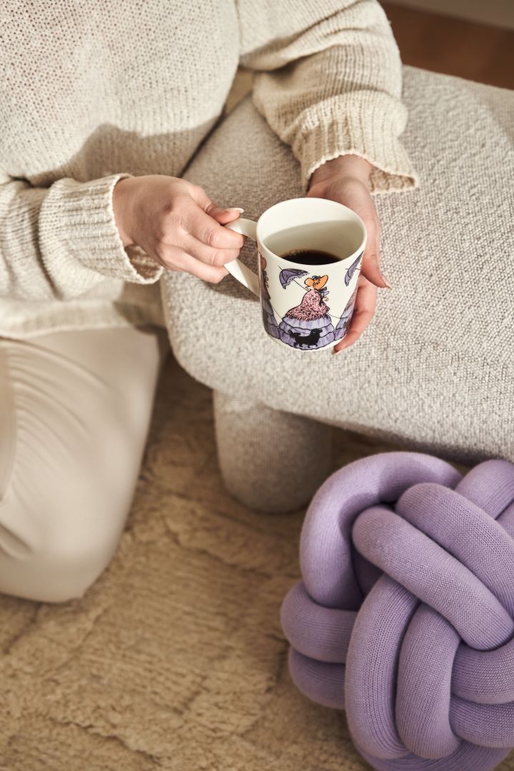 Eine Tasse mit einem Motiv der schwedischen Autorin Elsa Beskow (Tant Gredelin) von Design House Stockholm und ein lilafarbenes Knot Kissen