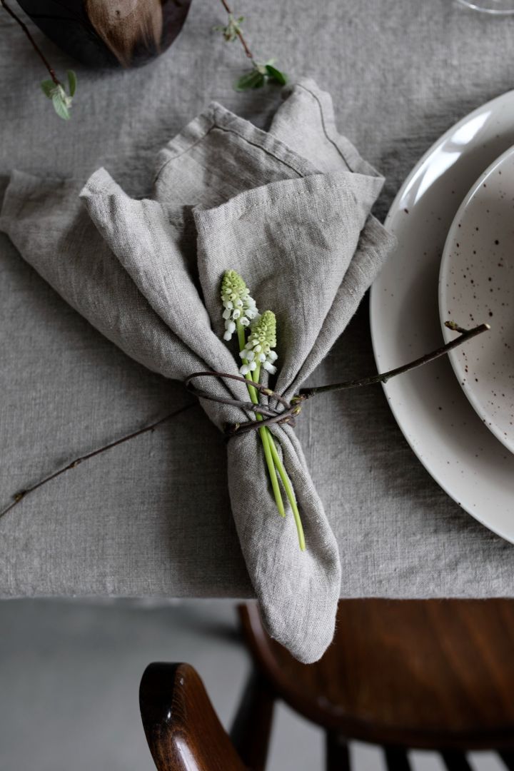 Servietten falten: Für eine rustikalere Tischdekoration können Sie, so wie hier, einfach etwas aus Ihrem Garten um die Serviette binden.