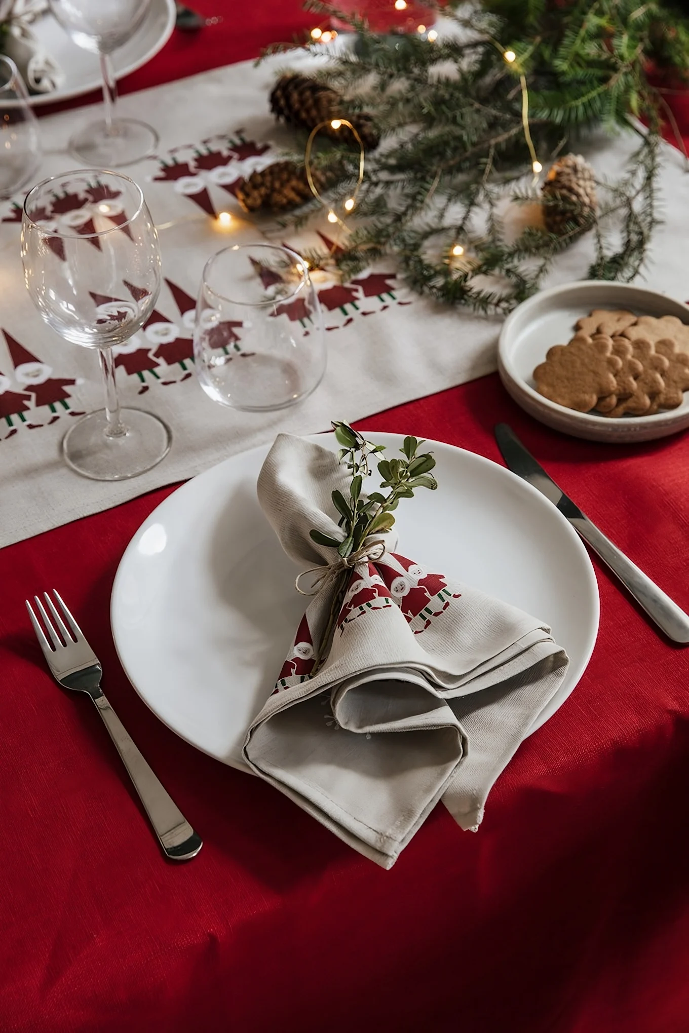 Zur perfekten skandinavischen Weihnachtsdeko gehören auch die passenden Textilien. Hier sehen Sie einen weihnachtlich gedeckten Tisch mit Tischdecke und Serviette aus der Tomtenisse-Kollektion von Almedahls.
