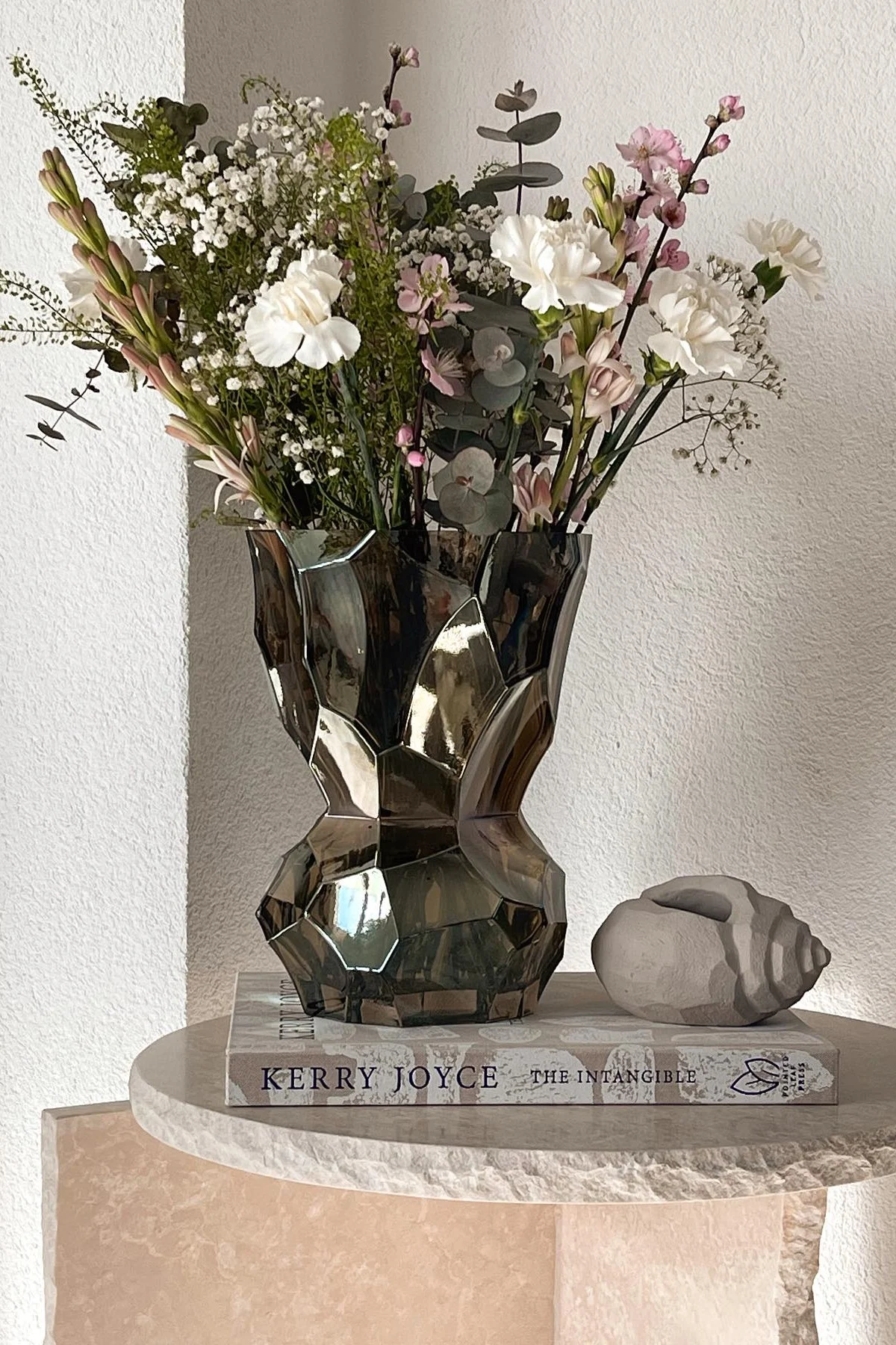 Auf dem Beistelltisch von @miia_home_interior steht die hohe Reflection Vase von Hein Studio mit einem frühlingshaften Blumenstrauß.