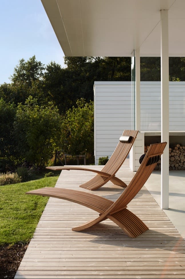 Gartenmöbel-Trends 2025: Die Sonnenliegen Nozib von Skargaarden bestehen mit ihrer organischen Form und stehen hier auf einer Terrasse mit Blick ins Grüne.