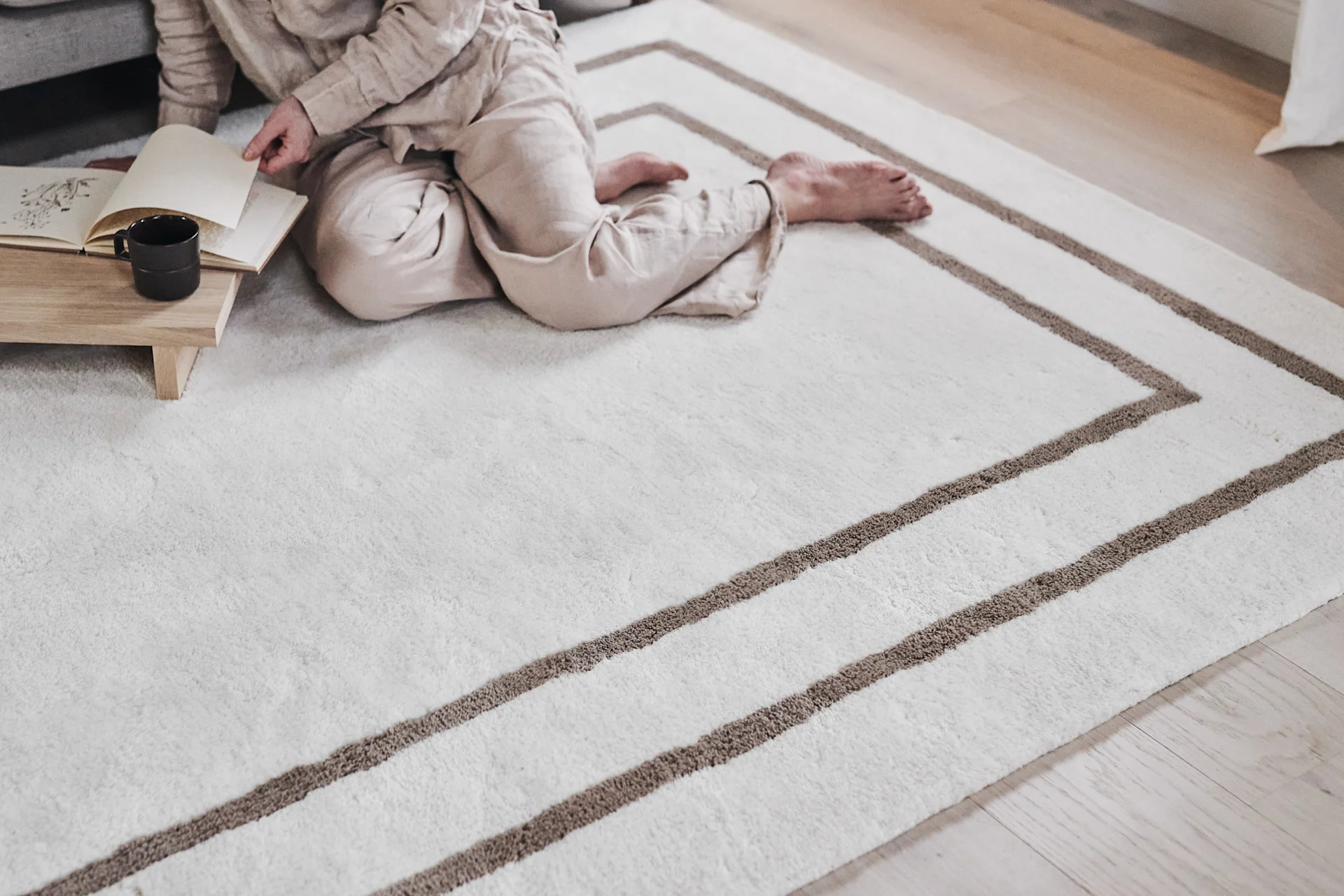 Kreieren Sie ein Schlafzimmer im Hotel-Stil und dekorieren Sie es mit einem luxuriösen Wollteppich wie dem Borders Teppich von Scandi Living. 