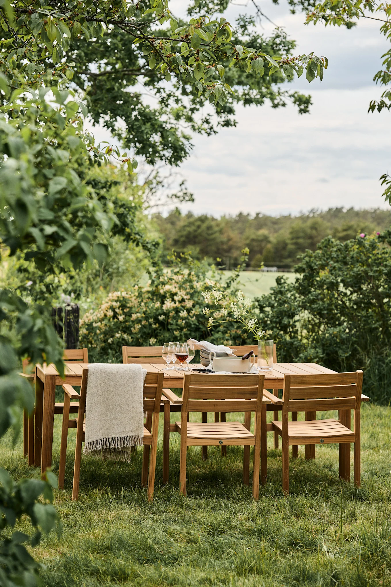 Gartenmöbel-Trends 2025: Die Sköndal-Stühle von 1898 stehen um einen Tisch herum in einem sehr grünen Garten.