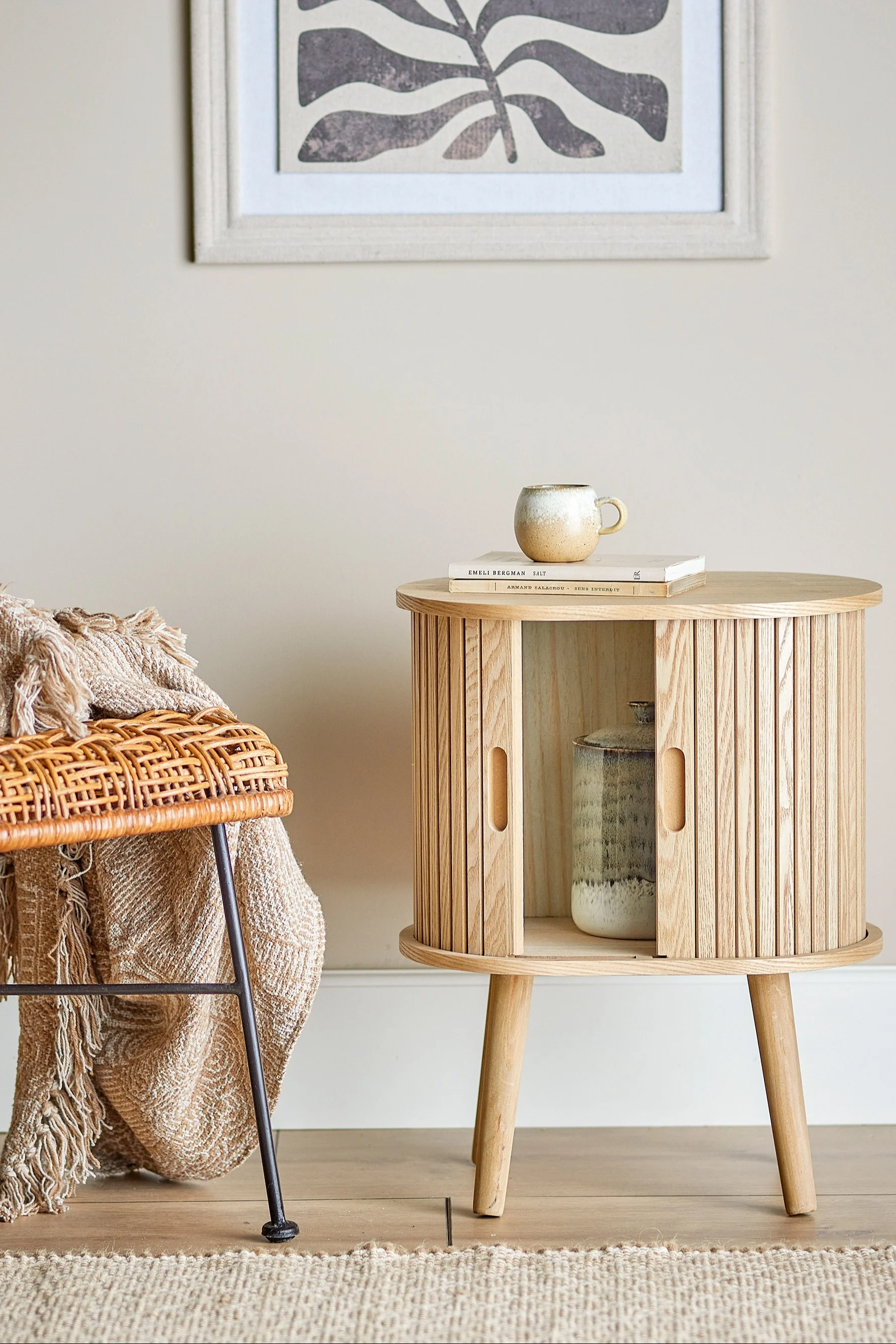 Der Salento Schrank von Bloomingville ist aufrund seines Designs die perfekte Boho Deko und steht hier in einem Wohnzimmer.