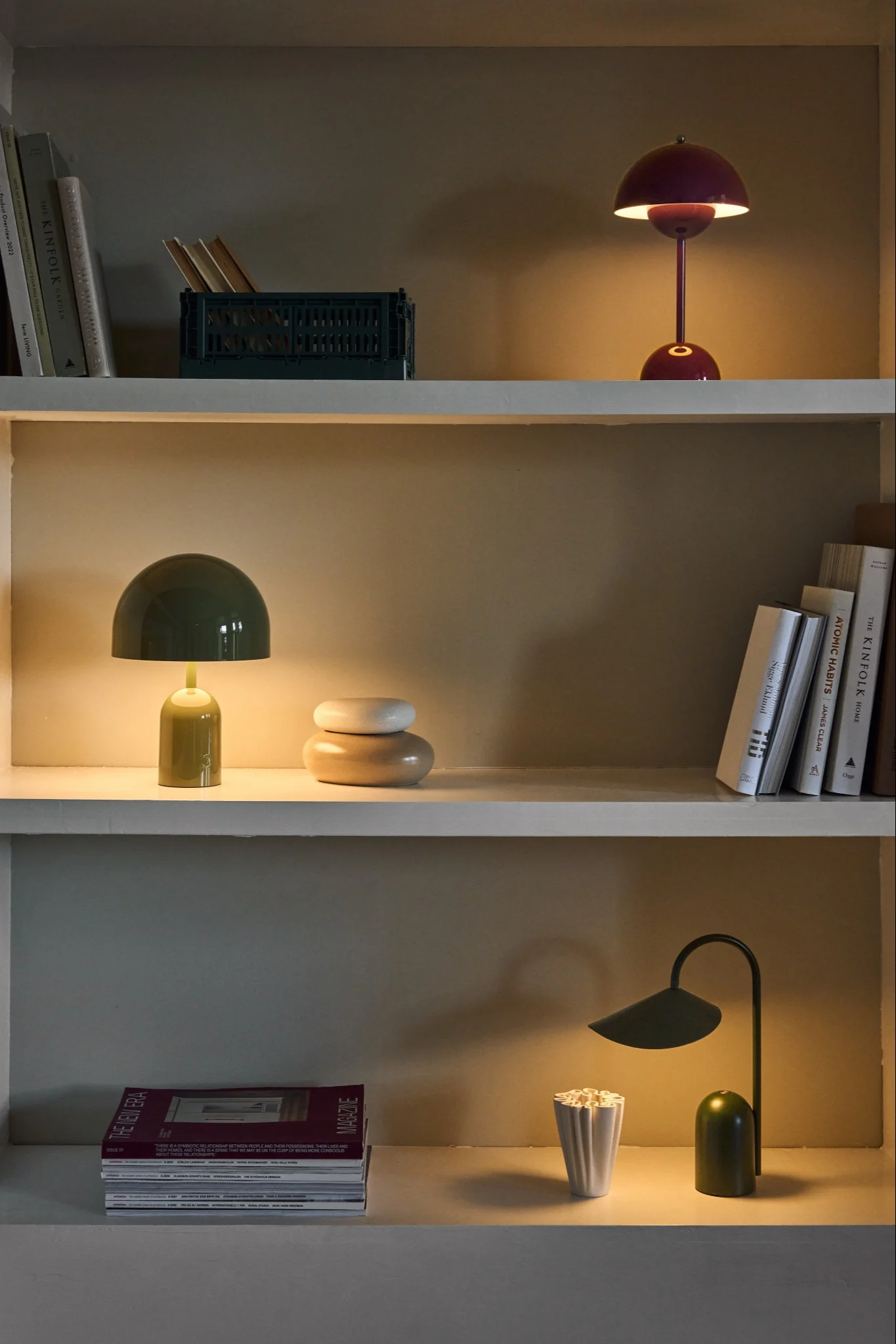 Ein Regal mit drei leuchtenden, wiederaufladbaren Lampen aus den Serien Arum, Flowerpot und Bell.