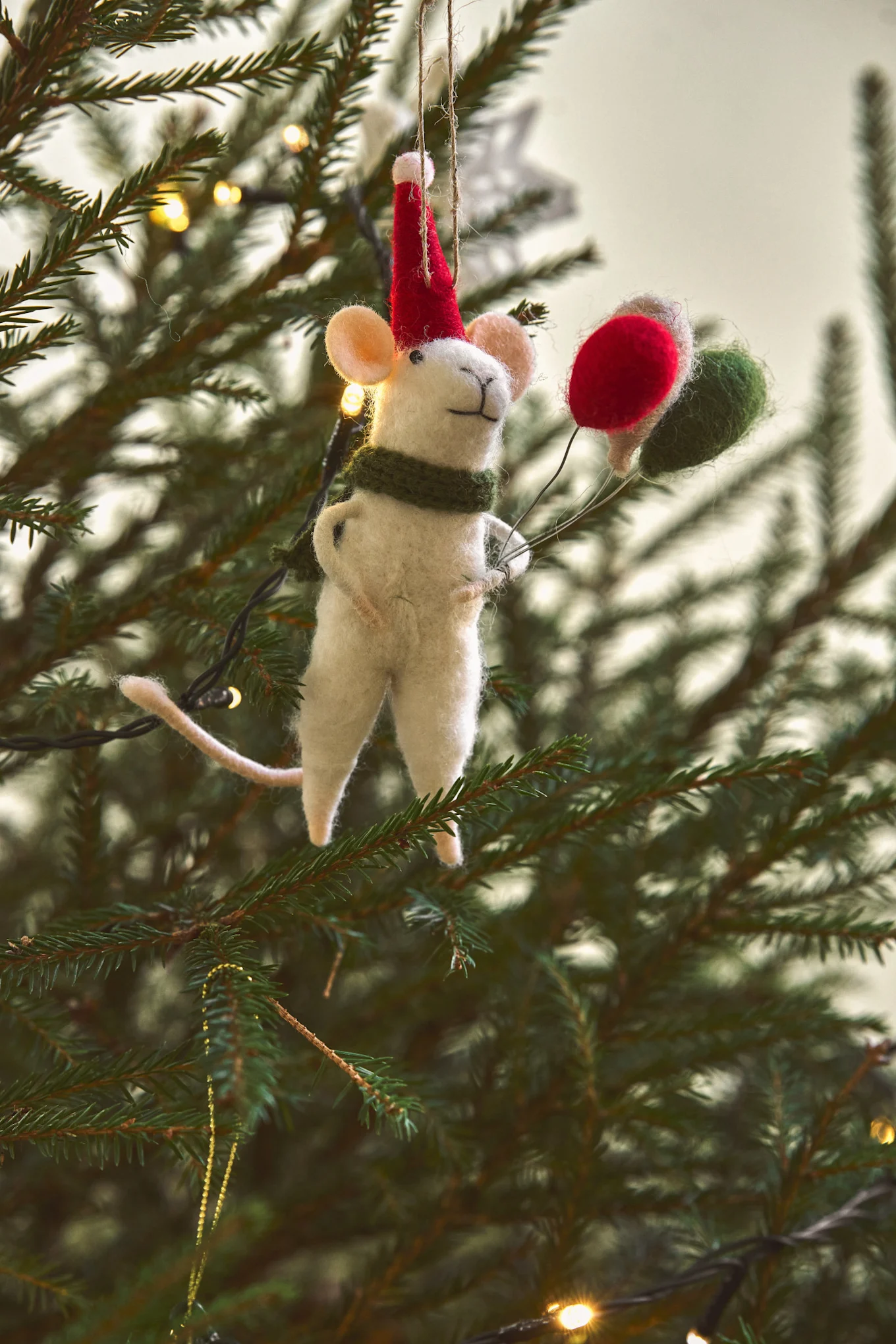Eine Maus mit Luftballons, von Bloomingville, hängt hier als Baumschmuck an einem Weihnachtsbaum.