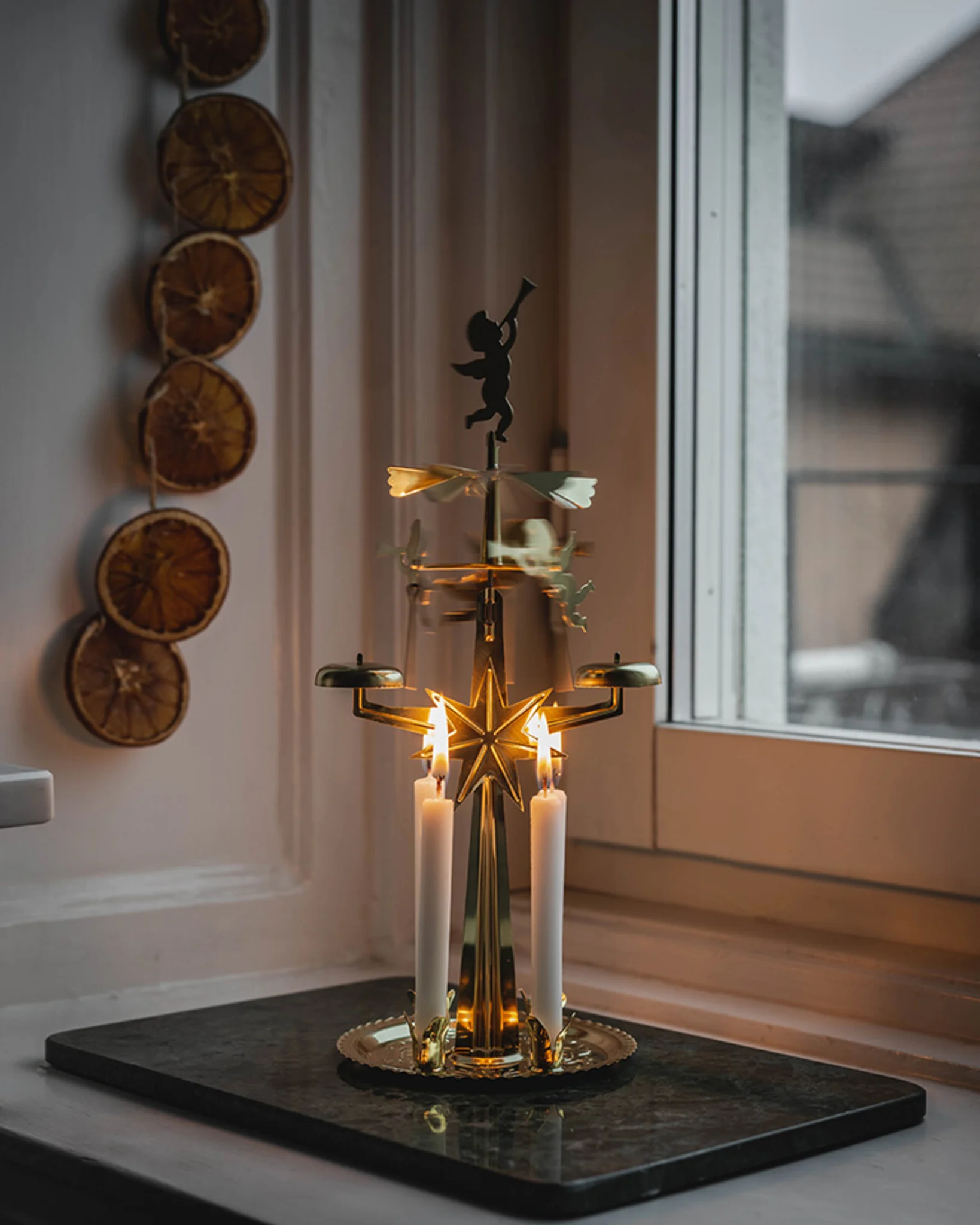 Auf einer Fensterbank steht ein Engelspiel - was eine typische Dekoration an Weihnachten in Schweden ist.