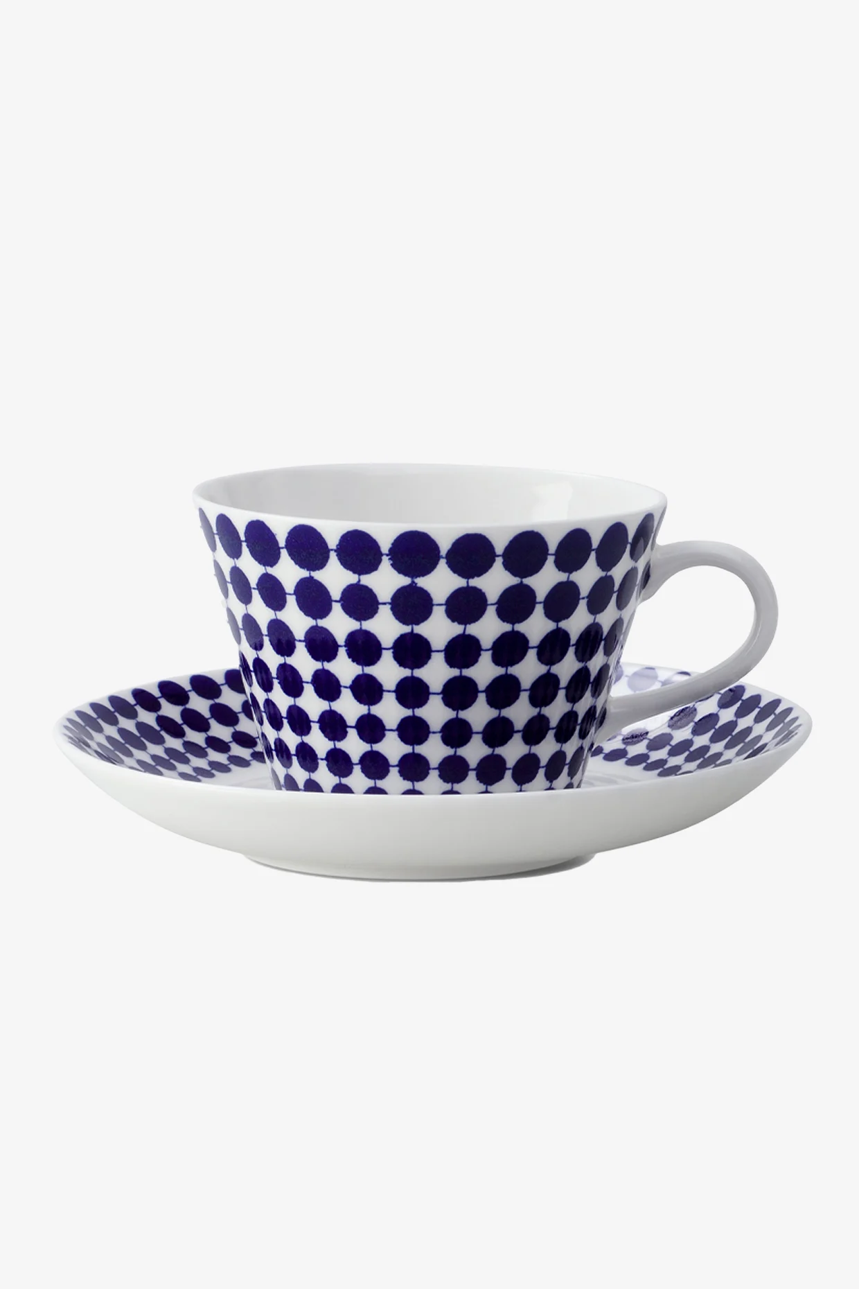 Weiße Teetasse und Untertasse mit blauem Punktmuster.