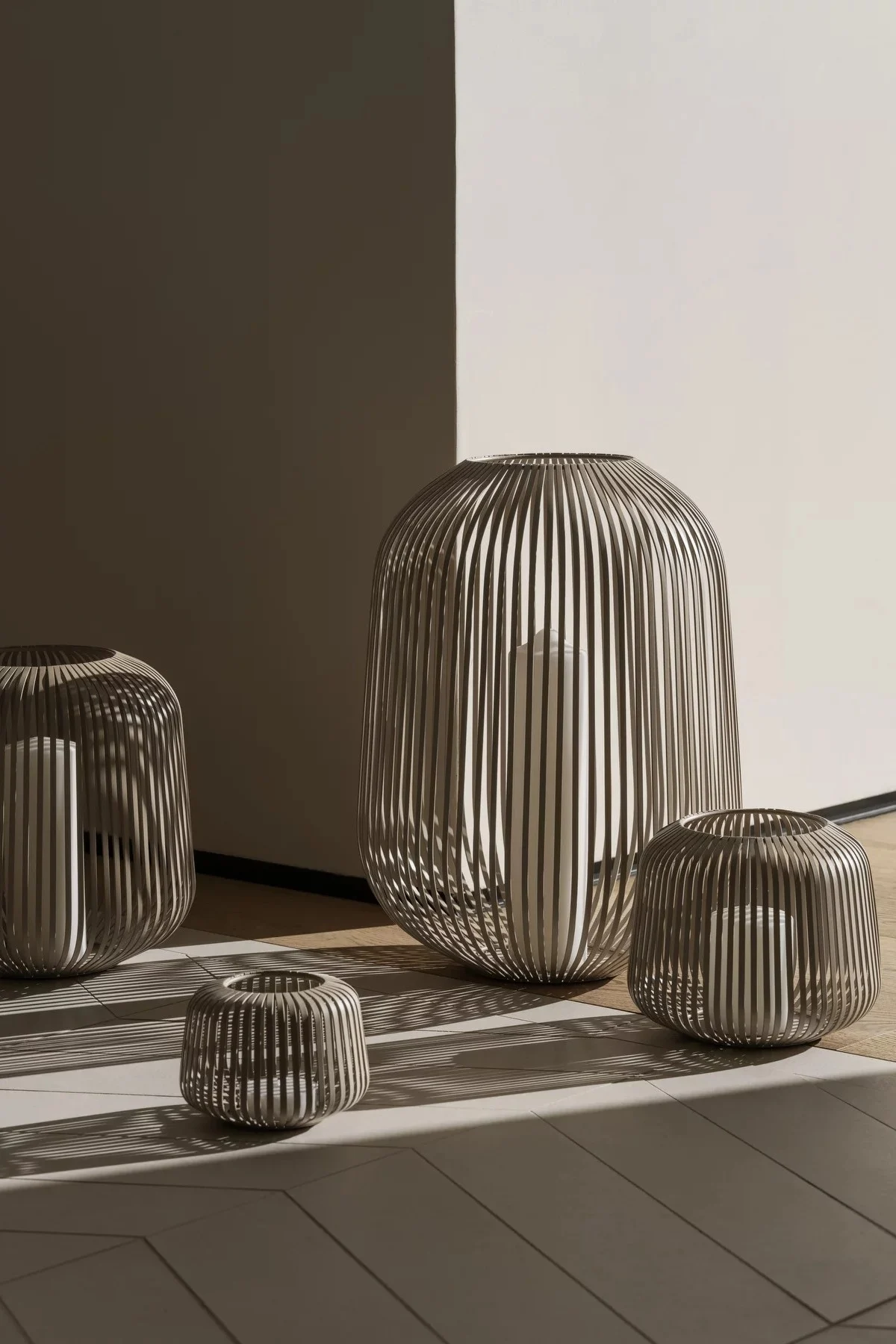 Laternen und Windlichter für draußen – hier sehen Sie die Lito-Laterne von Blomus in Nomad in verschiedenen Größen in einem Flur stehen.