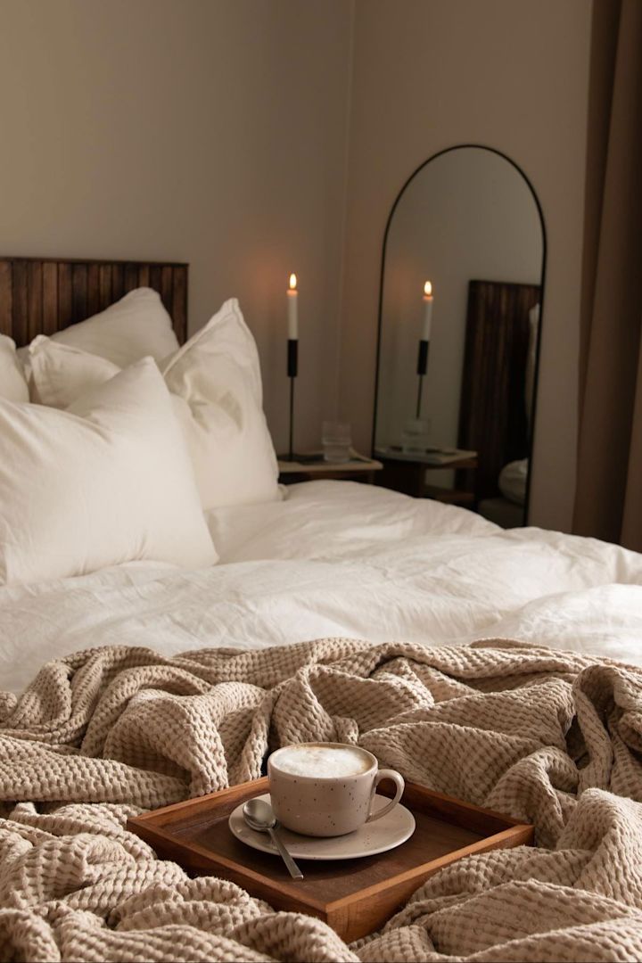 Die Freckle-Tasse in Beige von Scandi Living steht auf einem Holztablett in einem gemütlichen Bett im Schlafzimmer von @joanna.avento.