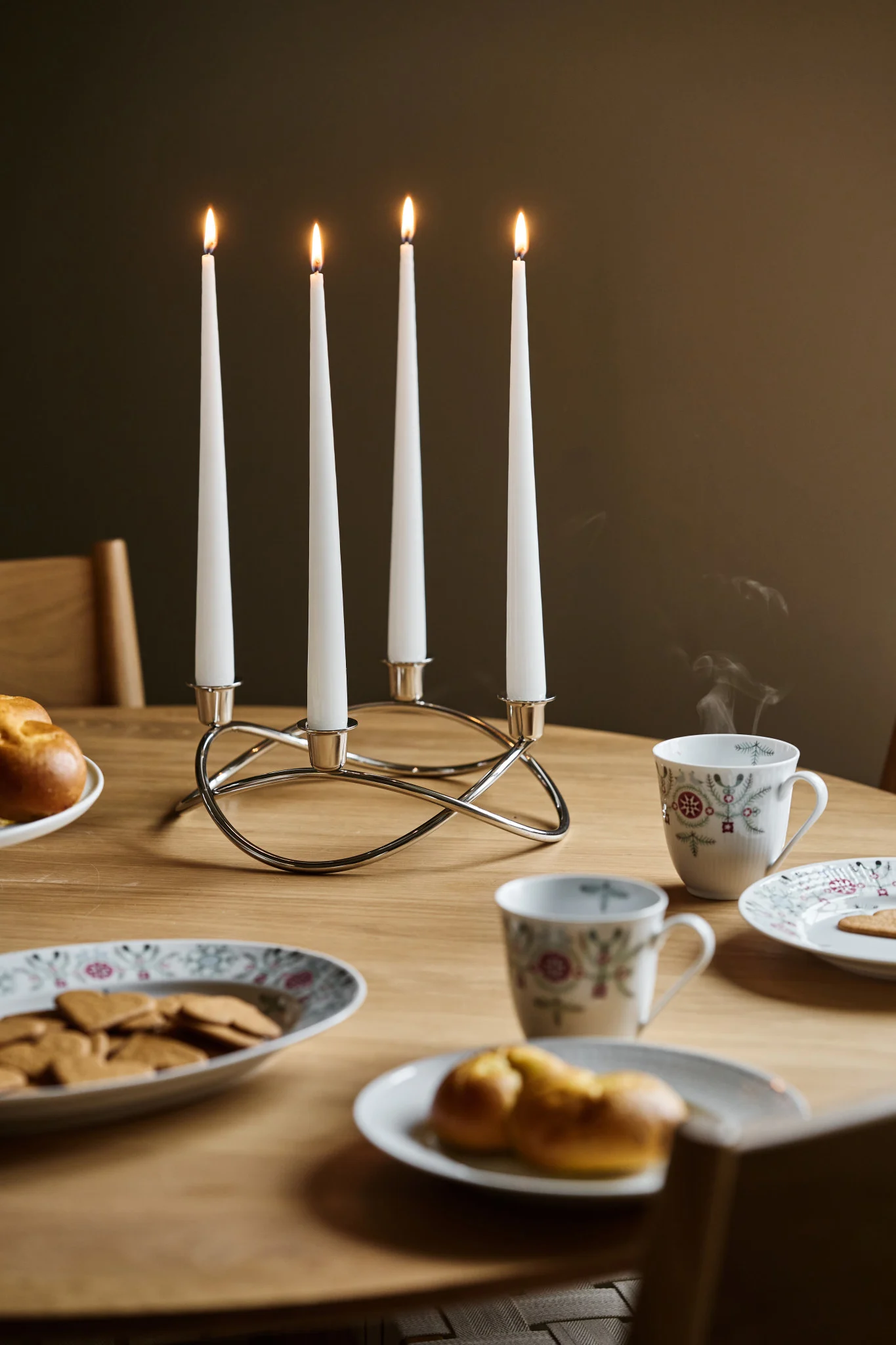Zu einem Glöggmingel gehört auch die richtige Dekoration: Hier sehen Sie den Season-Kerzenhalter von Georg Jensen auf einem Tisch stehen, daneben Weihnachtsgeschirr mit Lebkuchen und Safrangebäck.