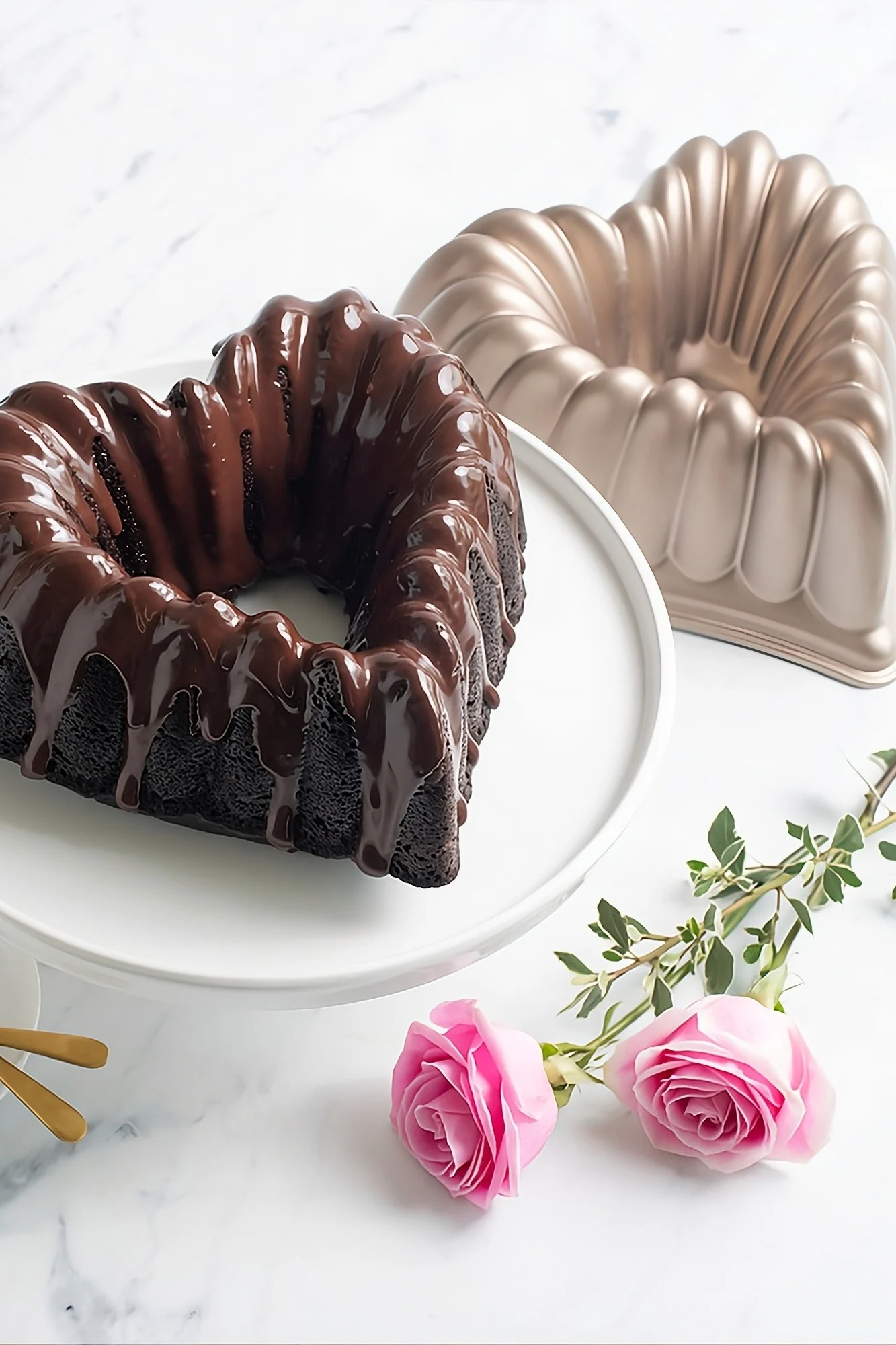 Backen Sie einen Kuchen in Herzform zum Valentinstag. Hier steht ein herzförmiger Schokoladenkuchen auf einem Tortenteller.