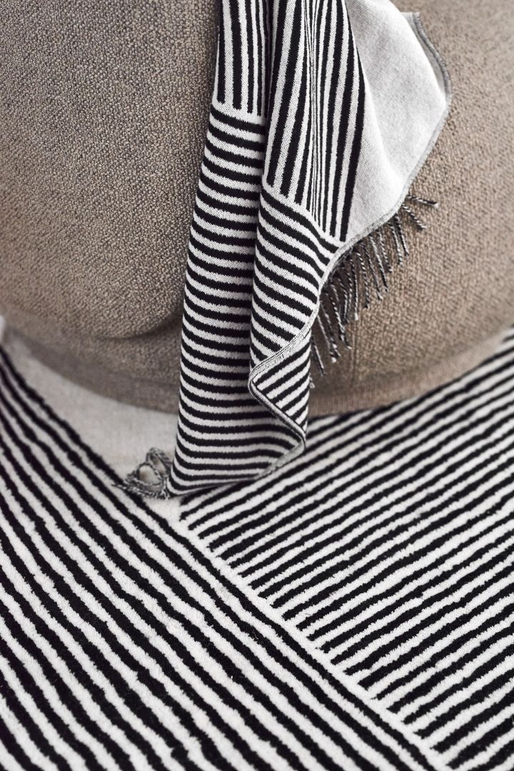 Textilien von NJRD: Die schwarz-weiß gestreifte Decke und der ebenfalls schwarz-weiß gestreiften Teppich.
