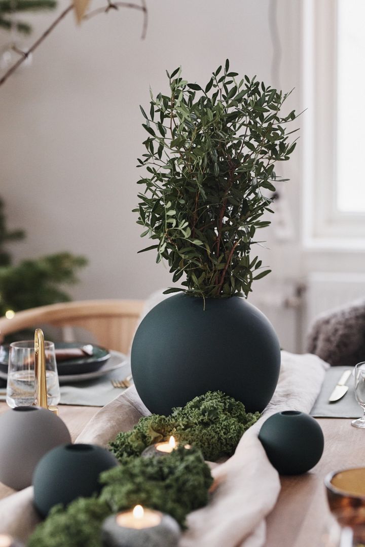 Die grüne runde Vase von Cooee Design schmückt die Weihnachtstischdekoration in Grüntönen mit Inspirationen aus der Natur.