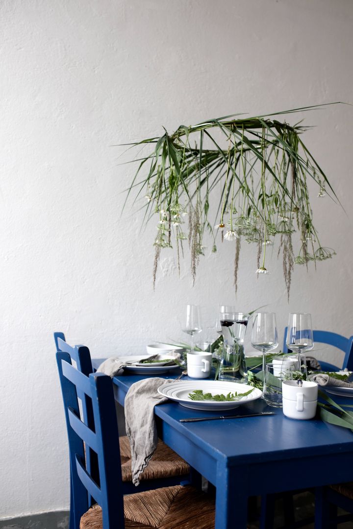Blaues Essgeschirr mit weißem Lines-Porzellan von NJRD und Grünpflanzen als Dekoration. Foto: @hemtrender