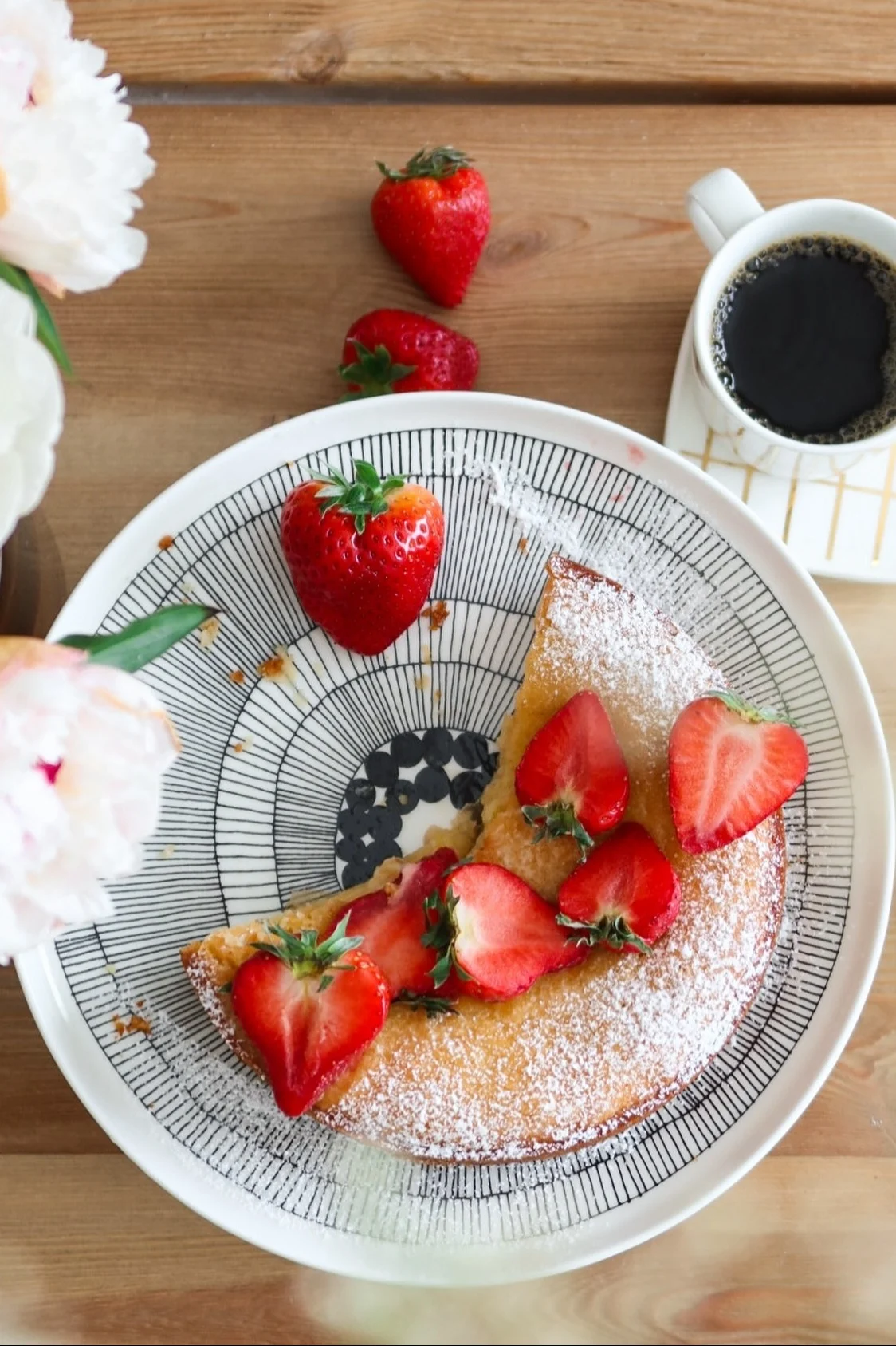 Kuchen gehört in Schweden zu einer Fika: Hier sehen Sie den Siirtolapuutarha Teller von Marimekko von oben mit einem Erdbeerkuchen, daneben eine Tasse Kaffee.