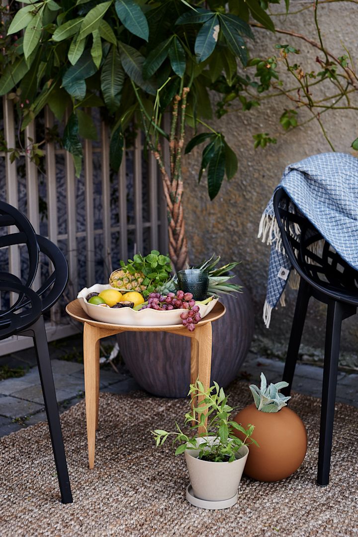 Tipps für einen Balkon im Boho Style – hier der klappbare Tisch von Fritz Hansen aus Eiche.