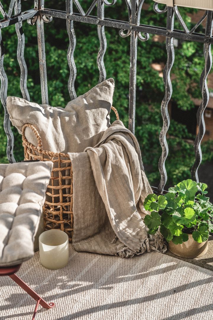 Tipps für die Dekoration eines kleinen Balkons - verwenden Sie Körbe, um Kissen und Decken aufzubewahren.