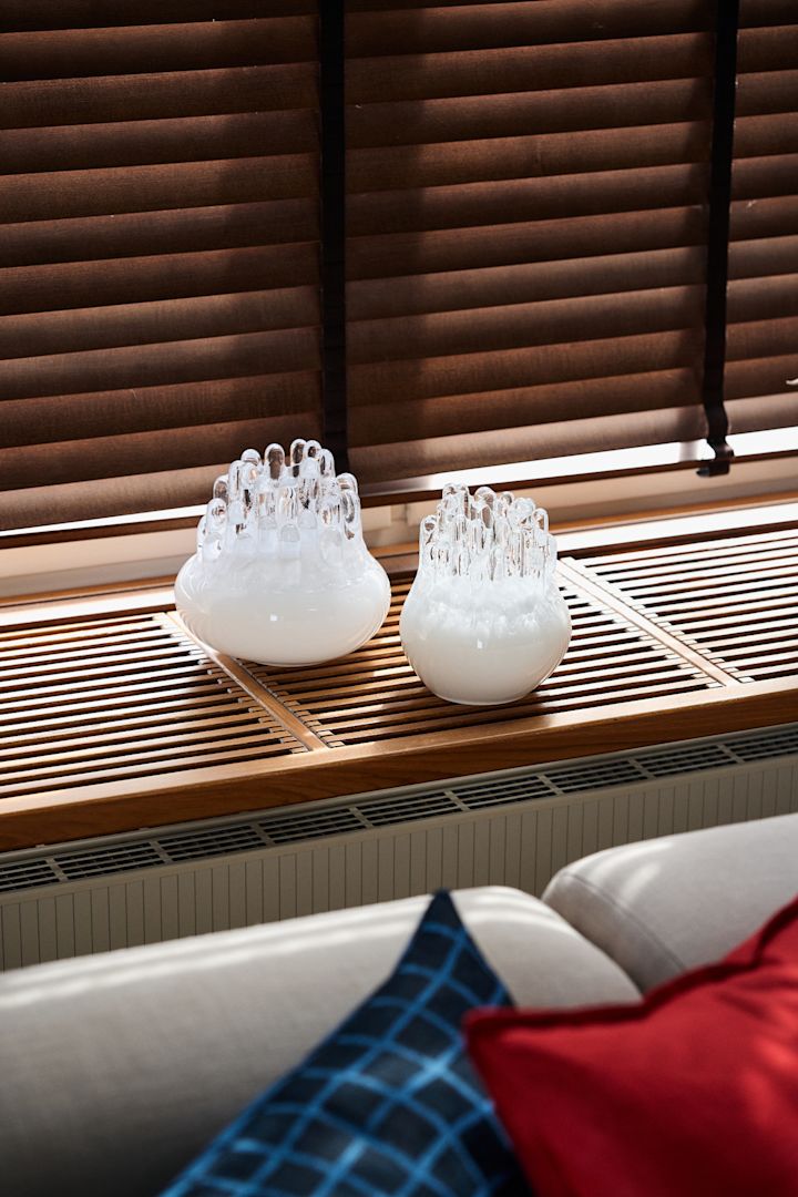 Wohntrends 2025: Zwei weiße Polar Kerzenhalter von Kosta Boda stehen auf einer Fensterbank.